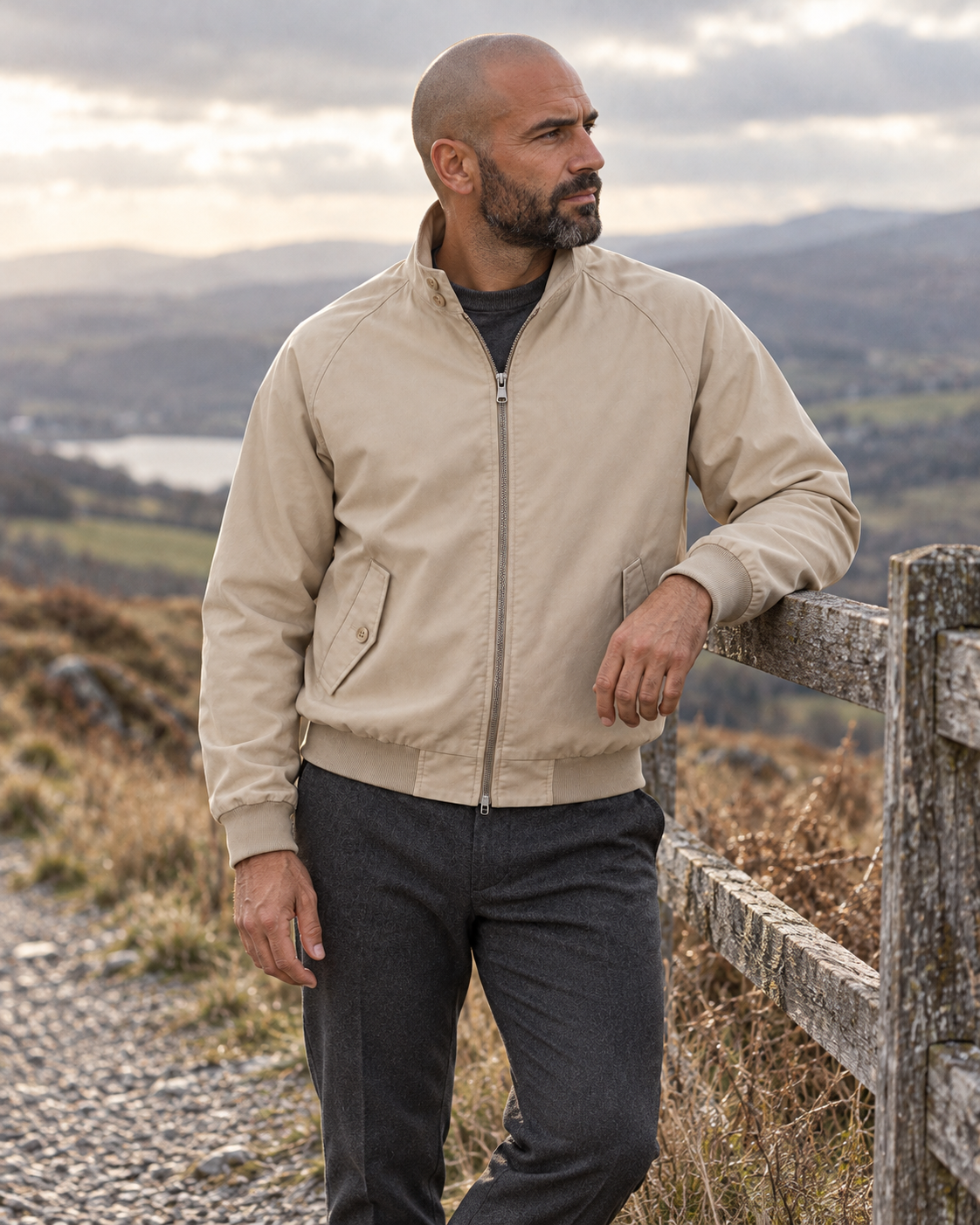 Man wearing the Harrington Jacket Timeless Refined beside a hilltop fence